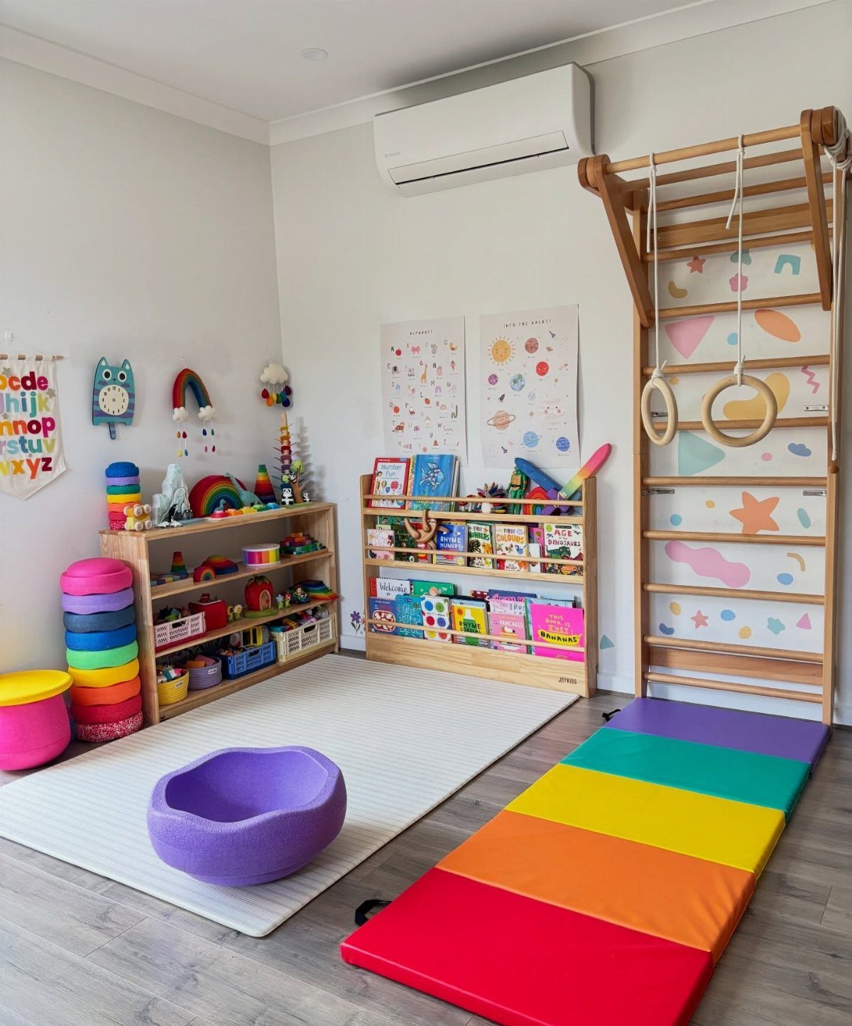 Children's playroom with wooden toy shelves, a climbing frame, and rainbow gym mat.