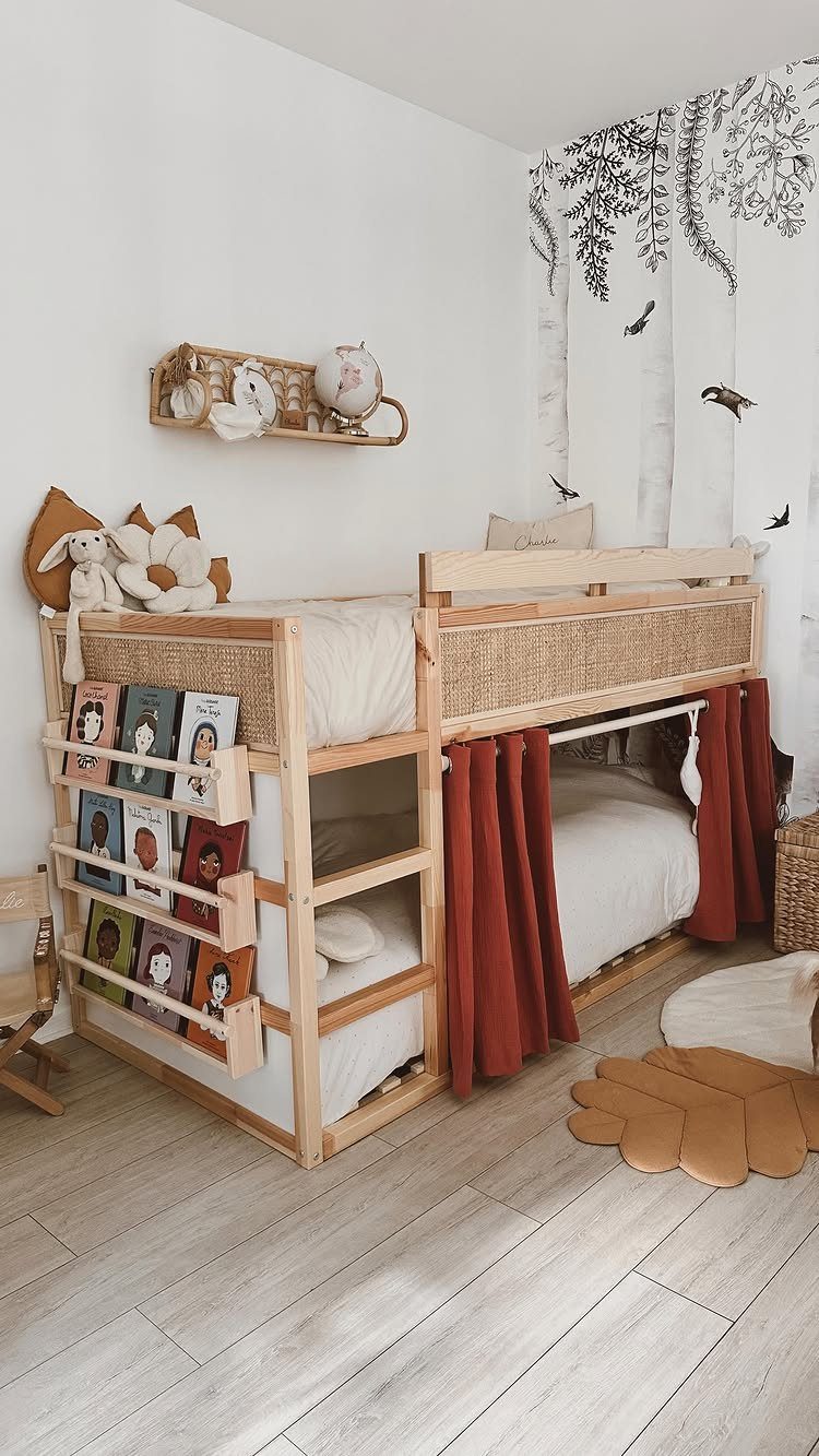 Light wood bunk bed with a built-in book rack and red curtains.