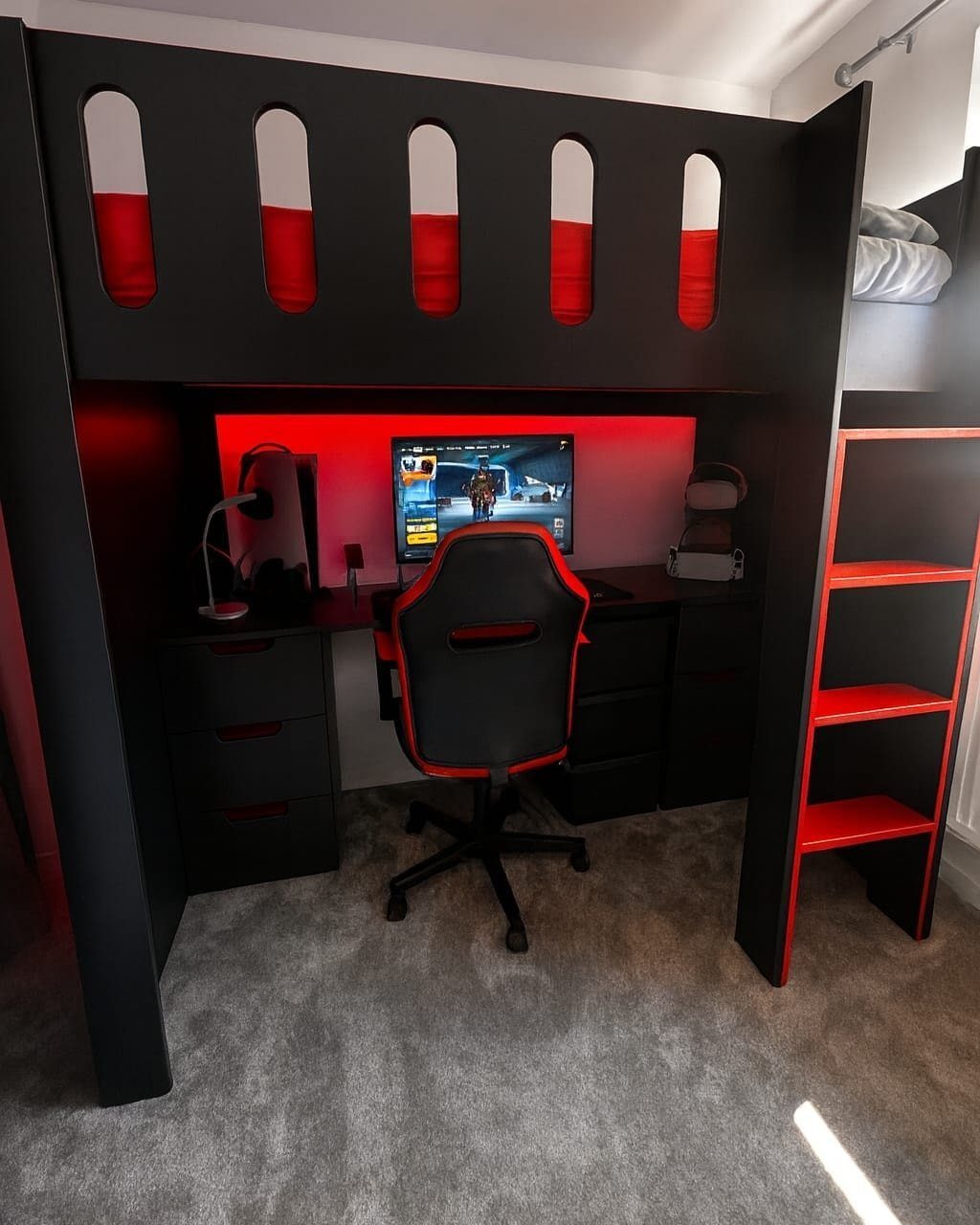 Black and red loft bed with integrated gaming desk and shelving unit
