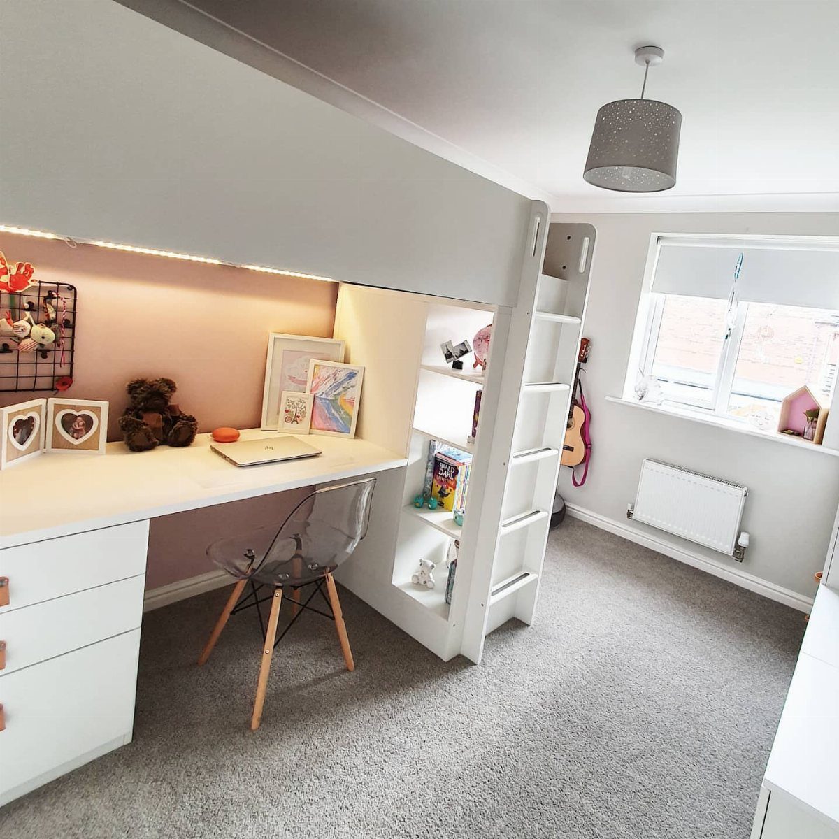 White loft bed with a built-in desk and clear chair in a bedroom