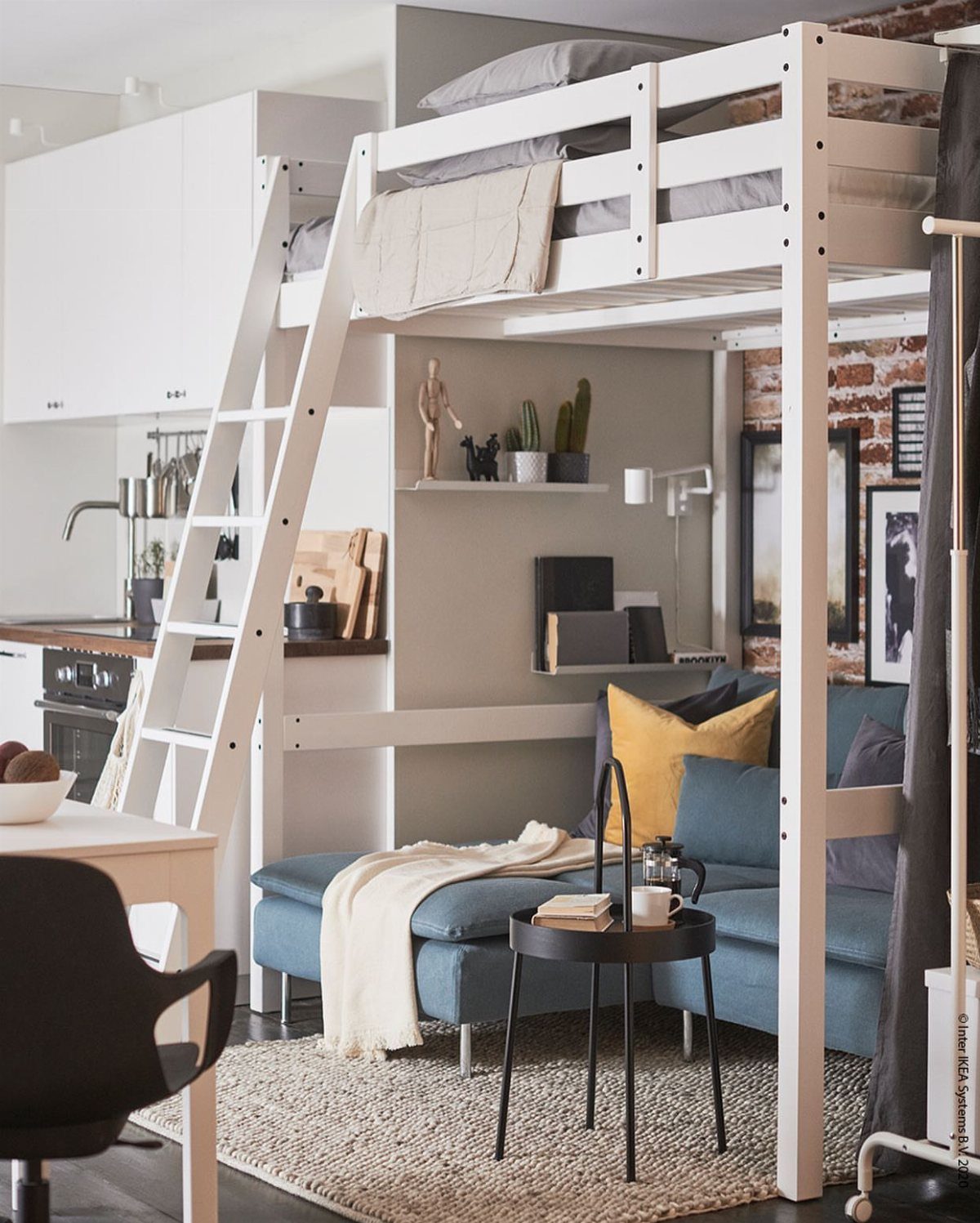 White wooden loft bed positioned over a blue sofa in a modern studio apartment.