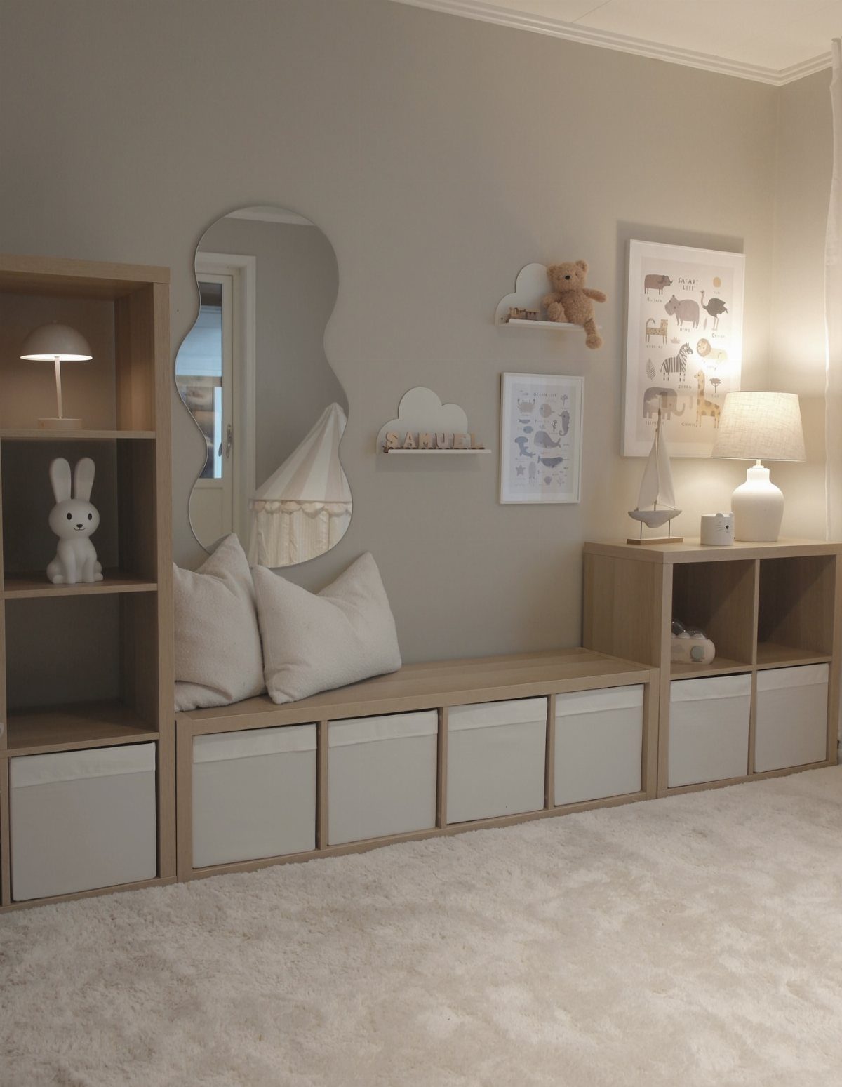 Beige nursery room with light wood storage bins, white pillows, and cloud shelves.