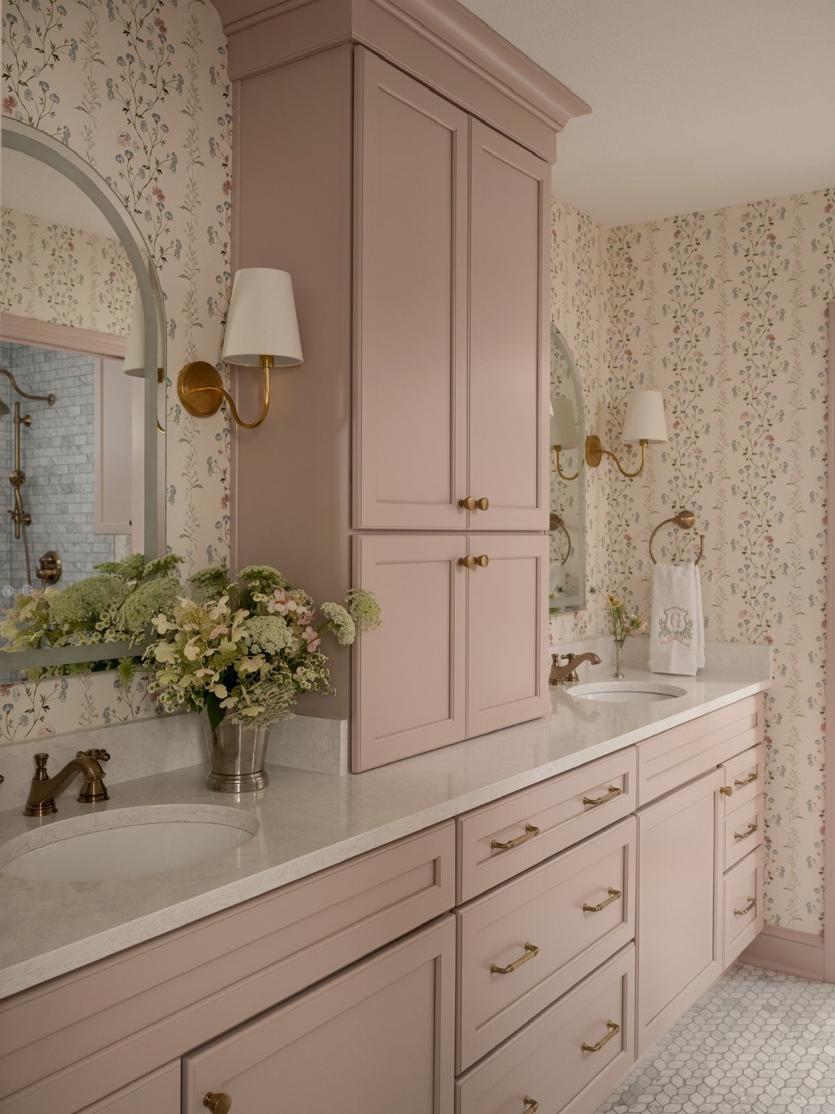 Dusty pink bathroom vanity with built-in cabinets, drawers, and white countertops.