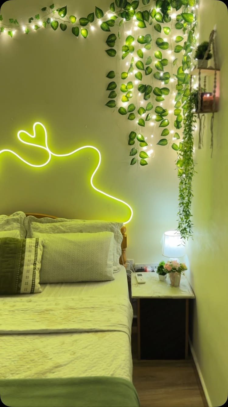 Bedroom with cascading green vines and white fairy lights hanging over a bed.