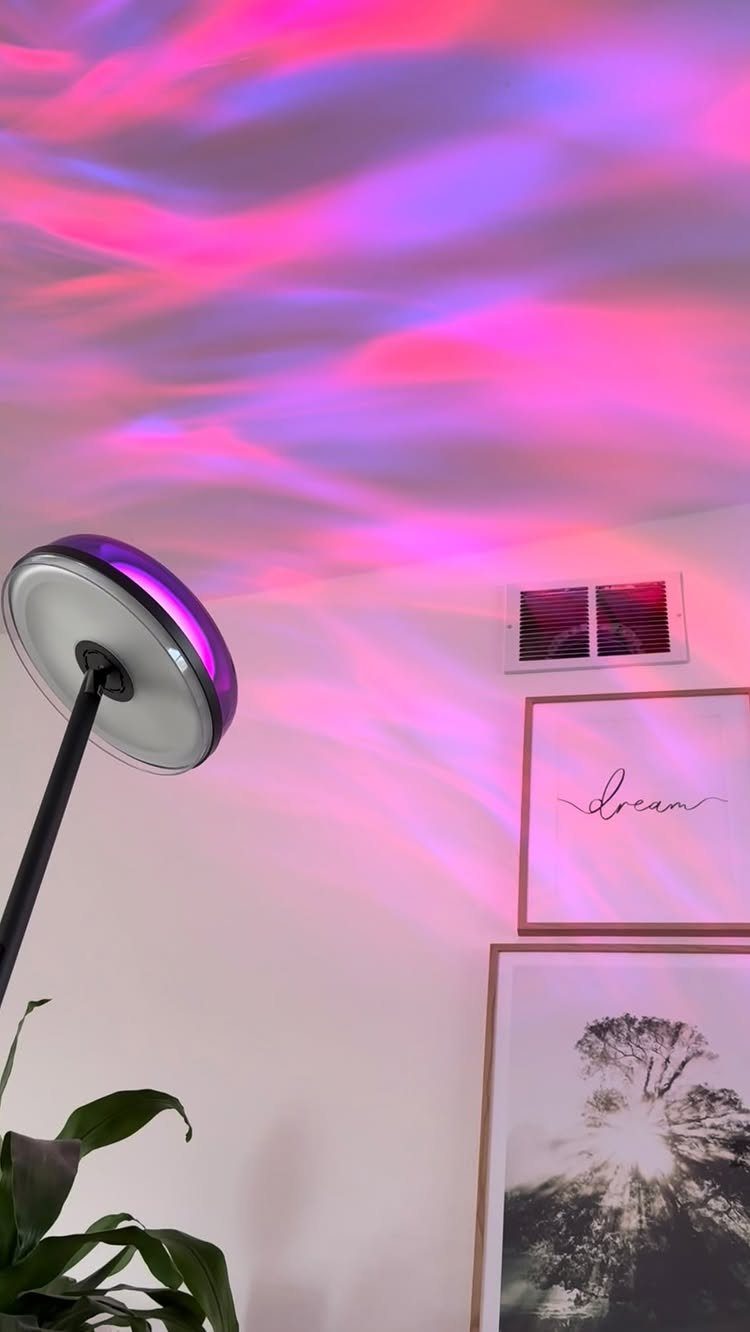 Modern floor lamp projecting pink and purple wavy light patterns onto a ceiling