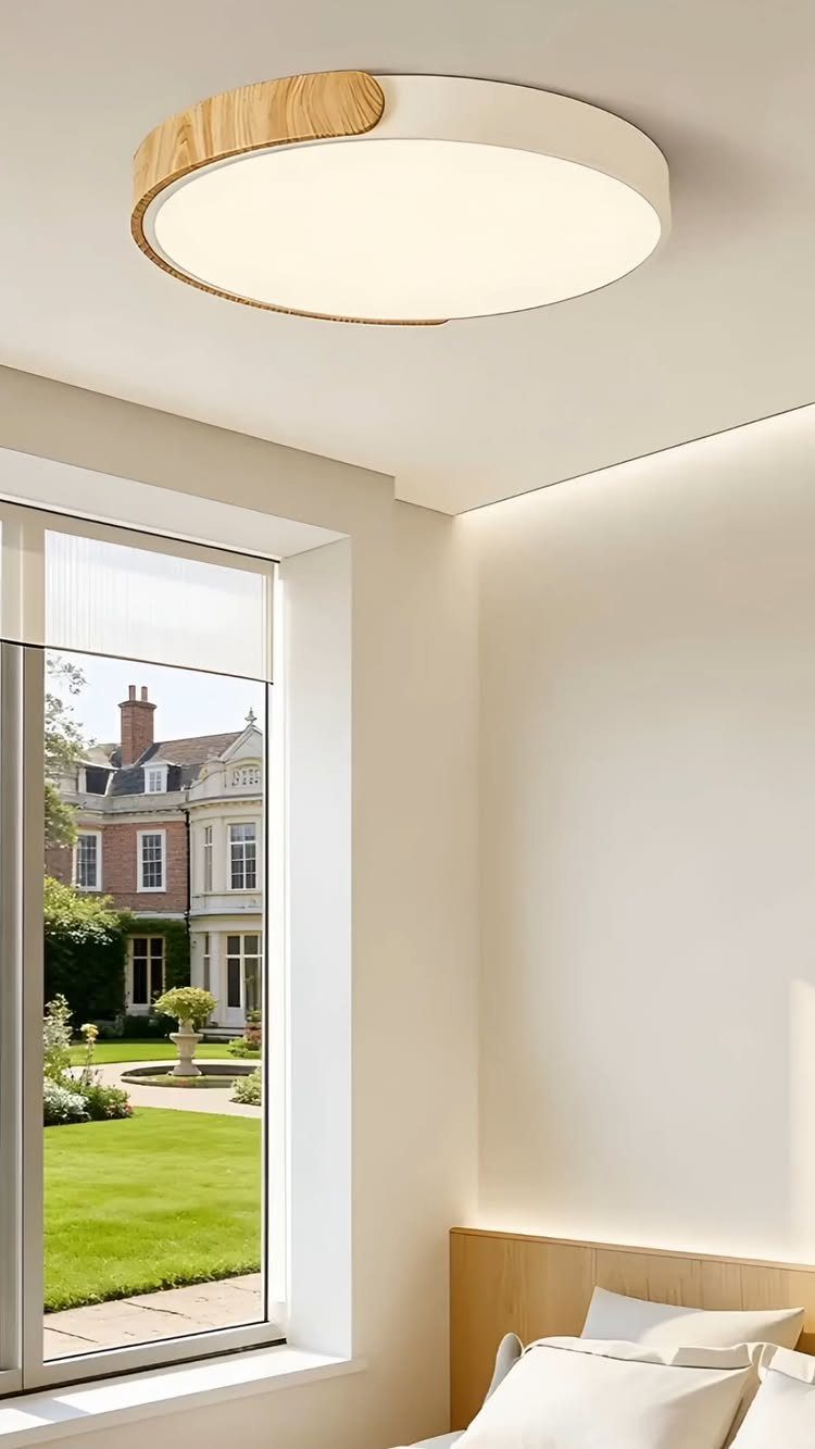 Circular white and wood ceiling light in a bright bedroom with garden view