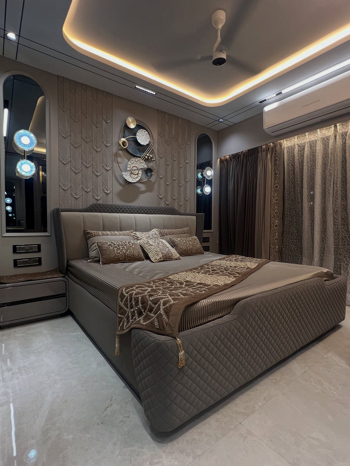 Modern bedroom with warm recessed ceiling lighting and a textured accent wall.
