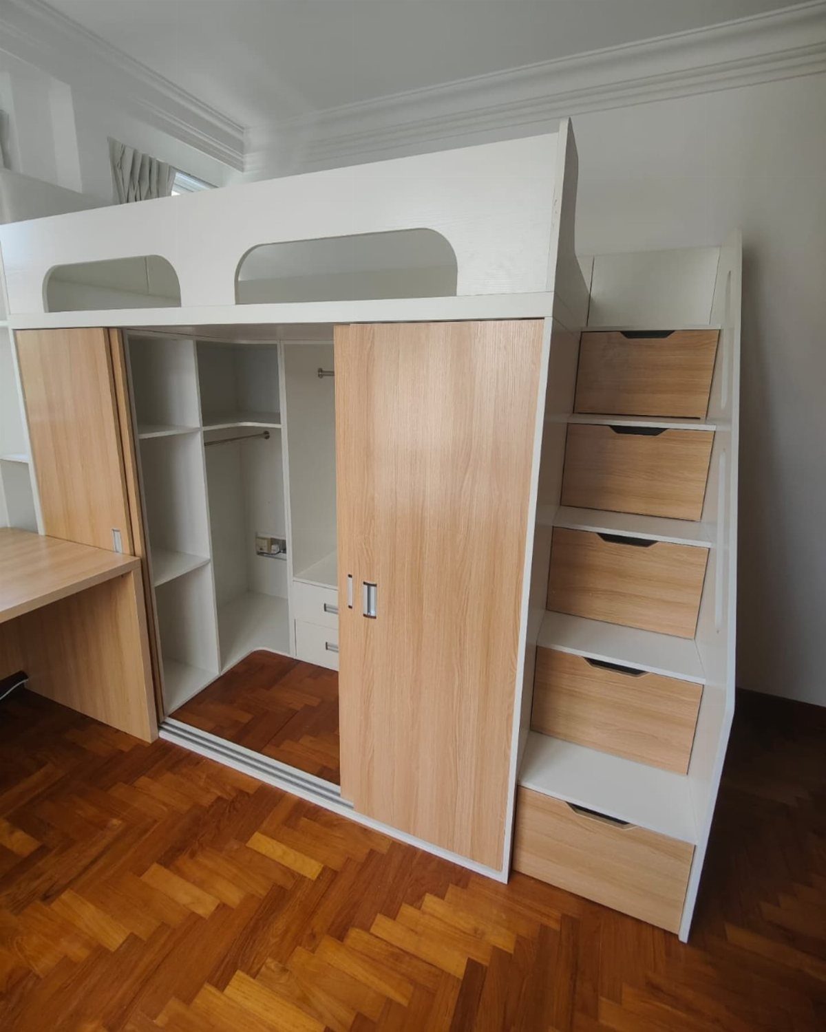 White loft bed with a built-in wooden closet and storage stairs underneath.