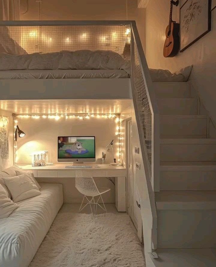 White loft bed with a desk, computer, and sofa underneath in a bedroom.