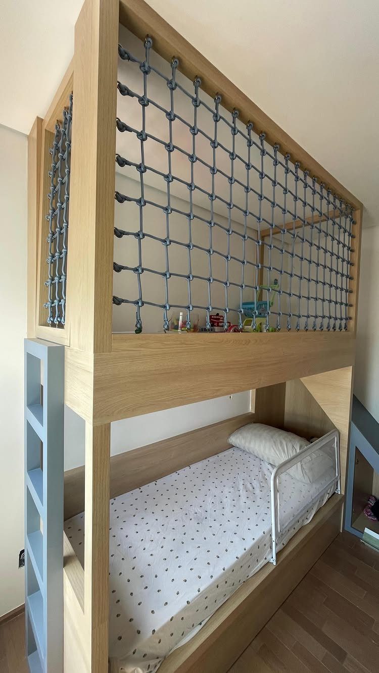 Wooden loft bed frame with a blue rope net and lower bed underneath.