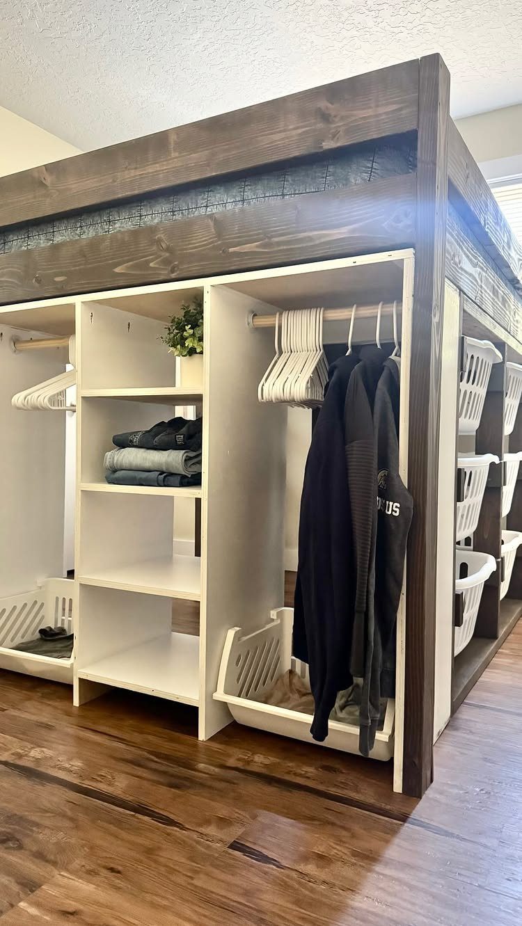 Dark brown loft bed with integrated white shelving, hanging rods, and storage bins underneath.