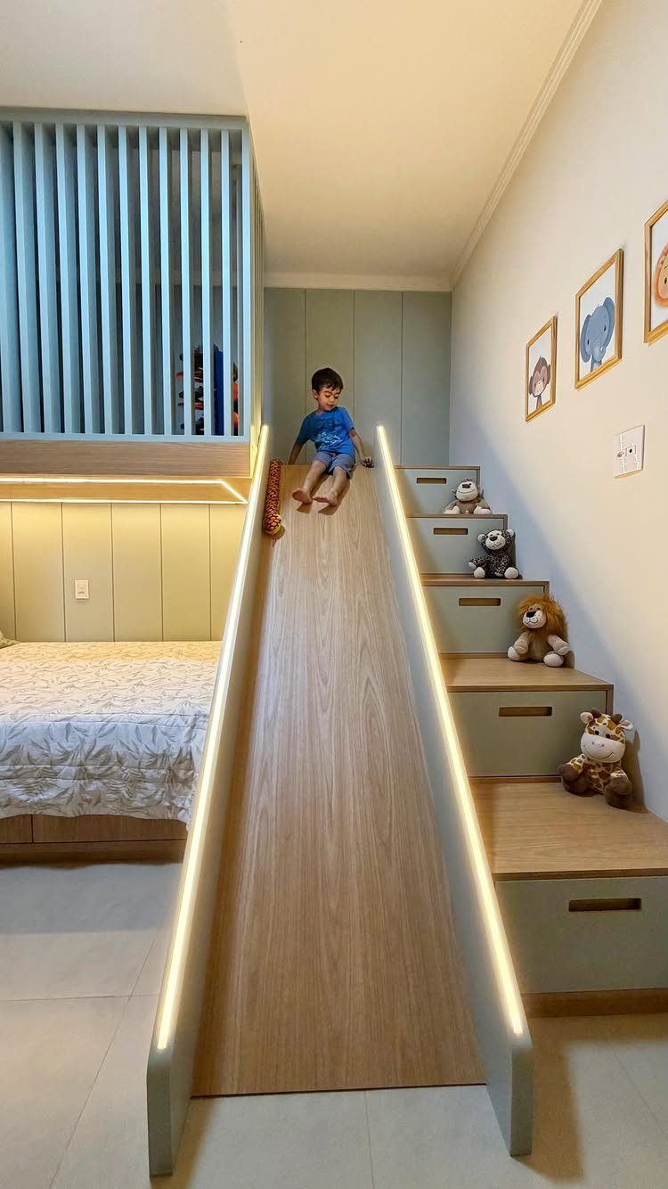 Child sliding down a wooden slide attached to a light green loft bed.
