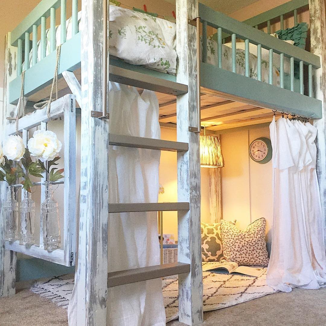 Sage green painted loft bed frame with a ladder and cozy nook underneath.