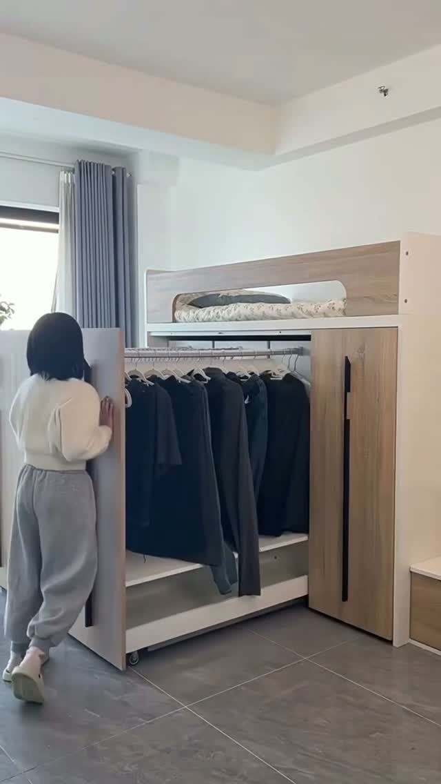 Loft bed with integrated wardrobe and hanging clothes storage underneath in a bedroom.