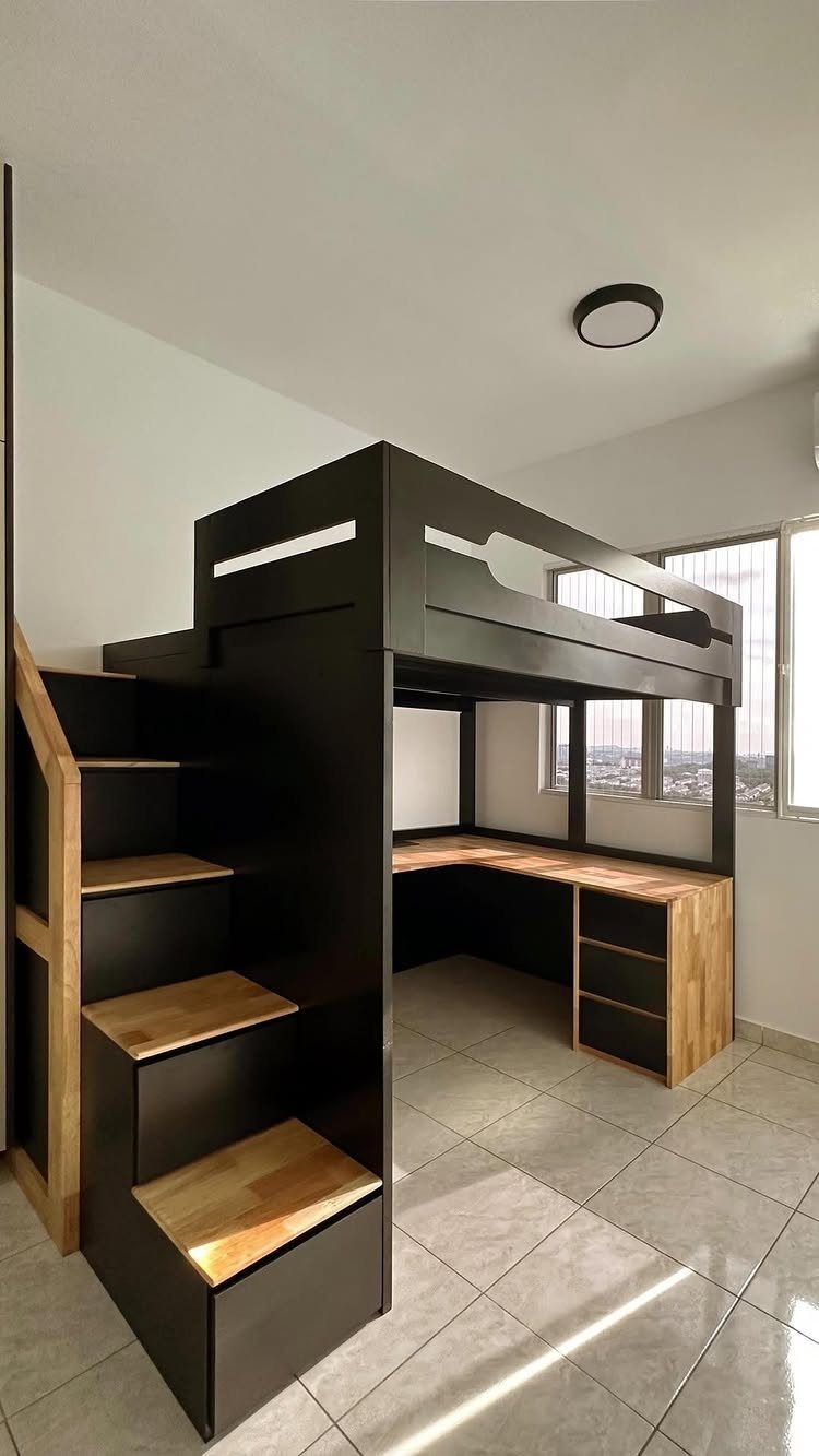 Black loft bed with wooden stairs and a built-in desk underneath in a room.