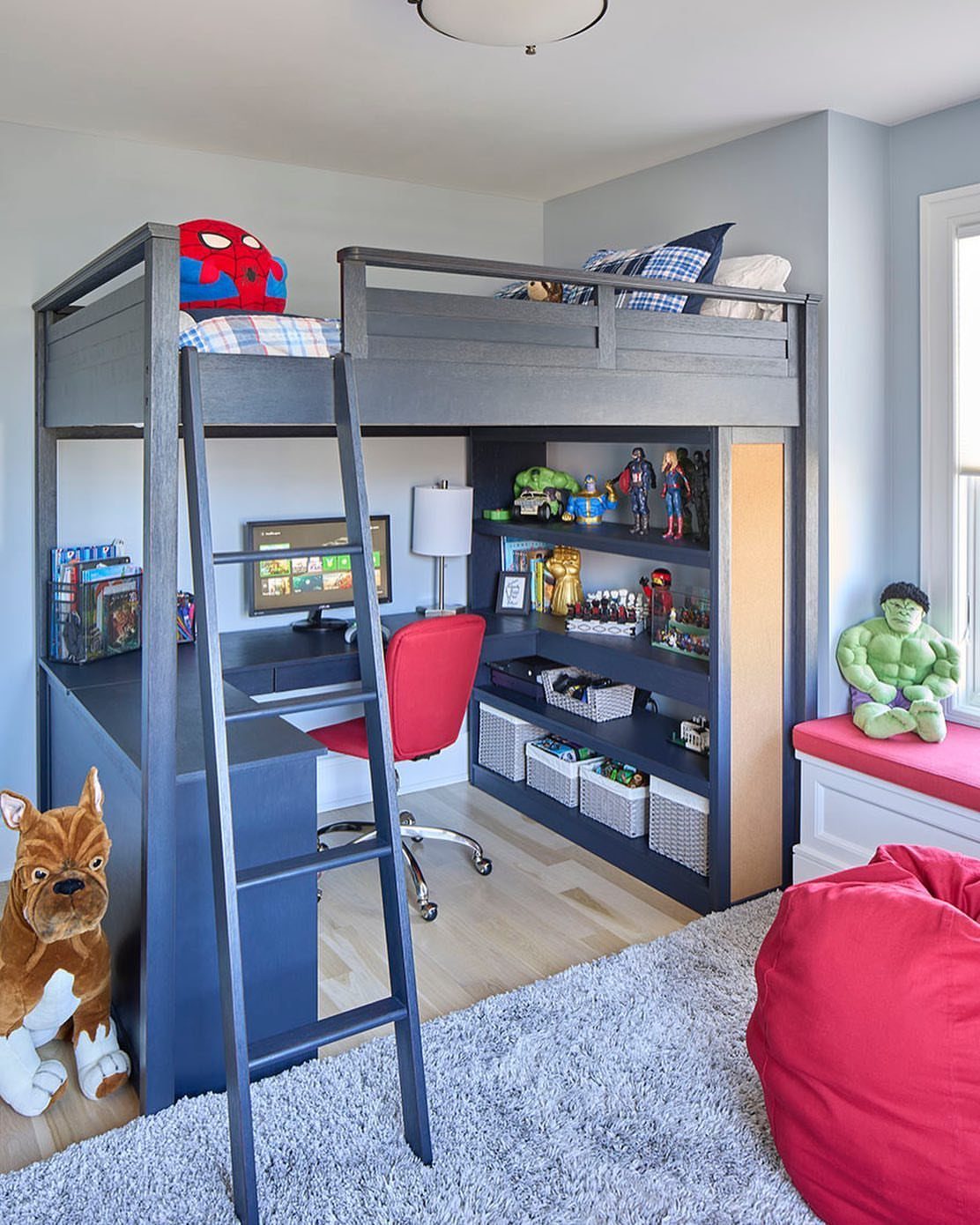 Grey wooden loft bed with integrated desk and shelving in a child's bedroom