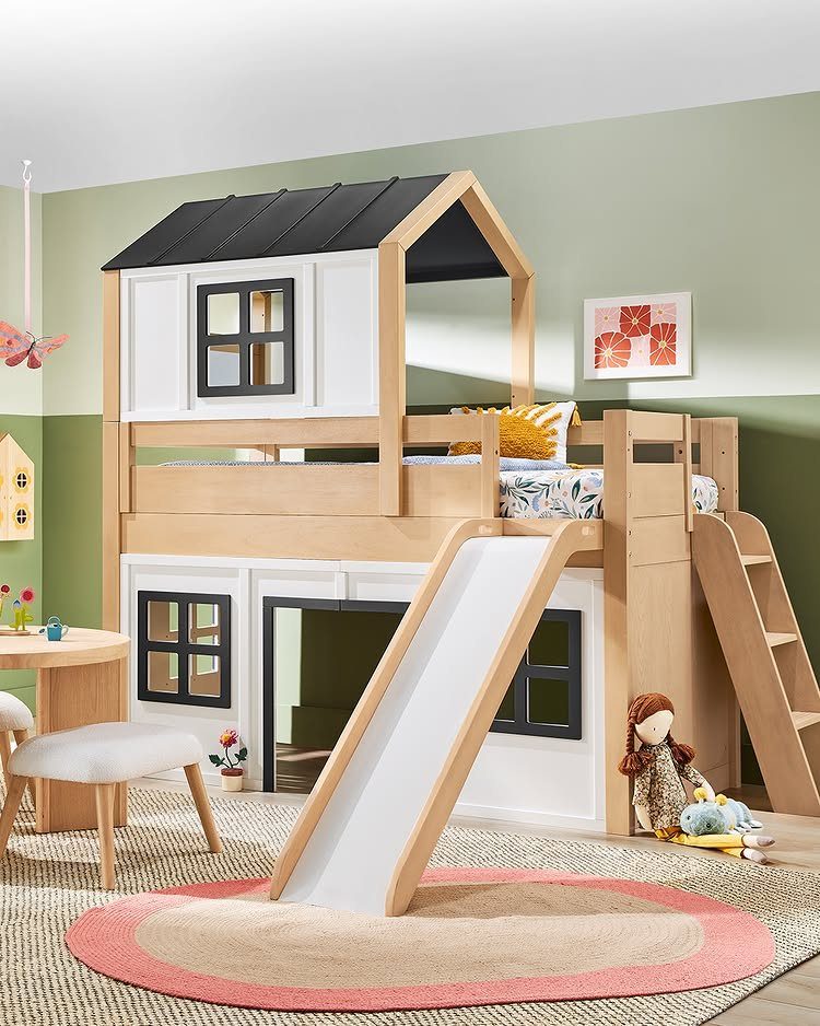 Playhouse loft bed with a house-shaped roof, white slide, and wooden ladder.