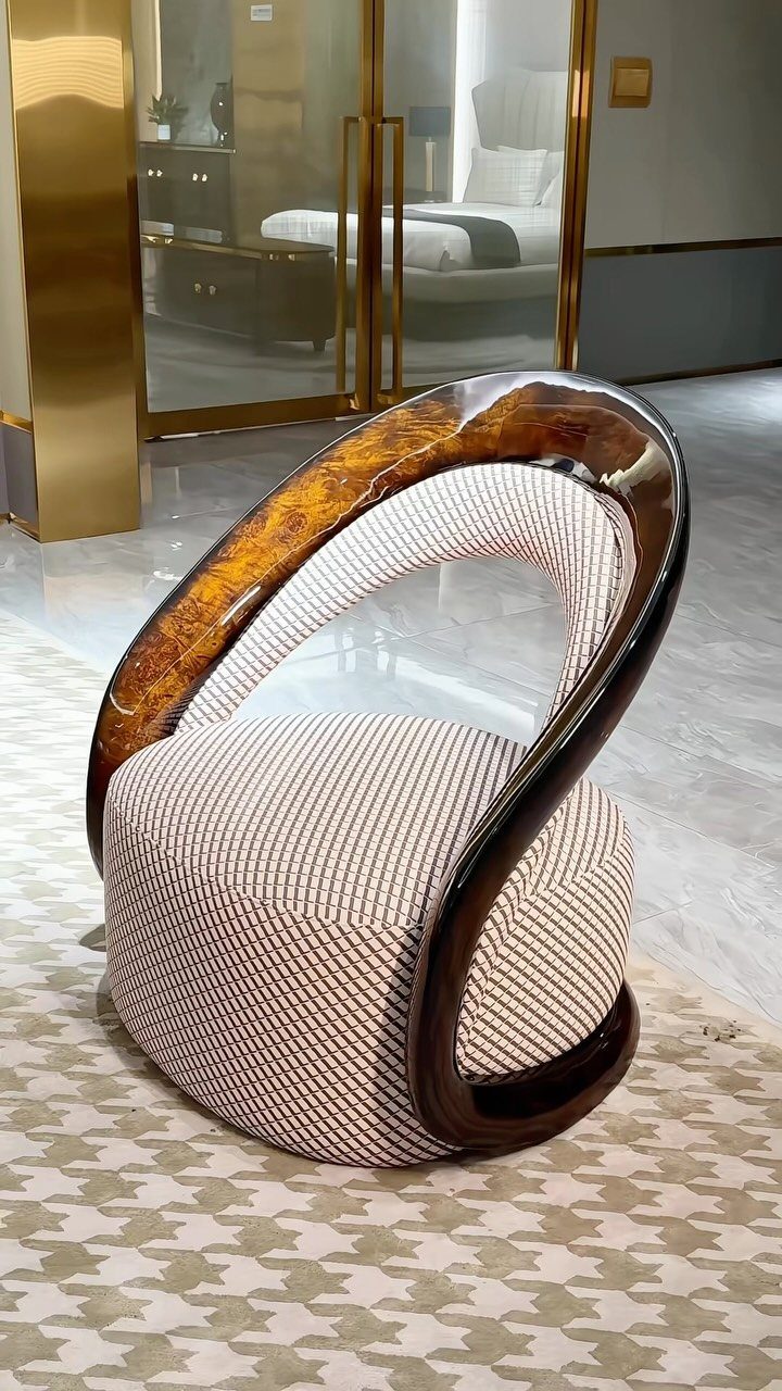 Modern lounge chair with curved wood frame in a bedroom setting