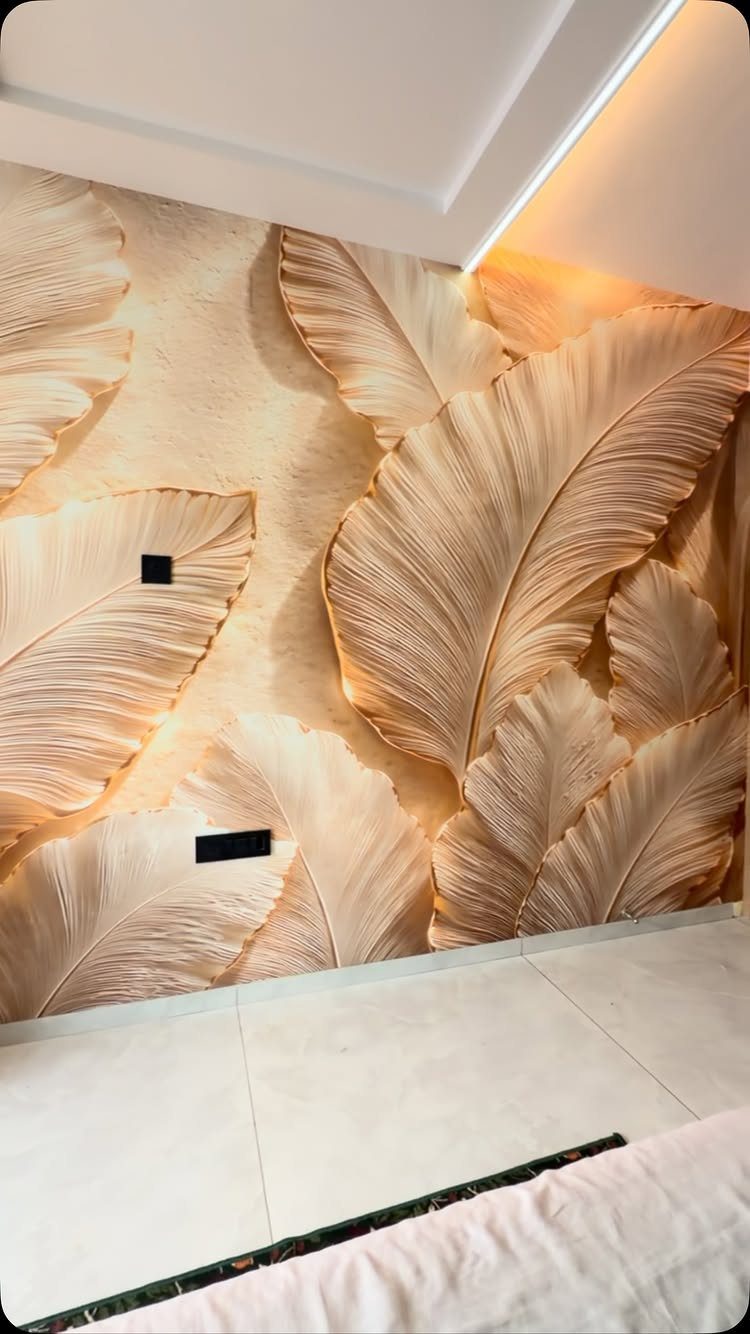 Gold leaf patterned wallpaper on a bedroom wall with warm recessed ceiling lighting.
