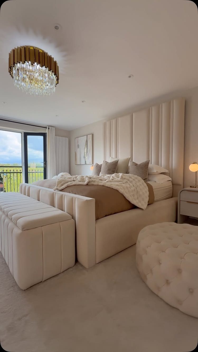 Cream tufted bench and round ottoman in a luxury neutral bedroom