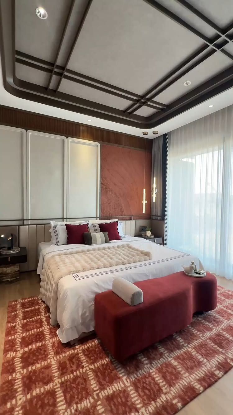 Modern bedroom with a bold red feature wall, white bed, and red rug.