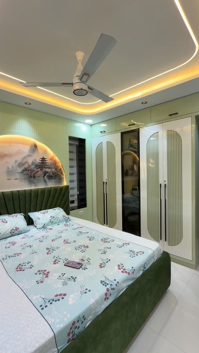 Green upholstered bed in a bedroom with a circular landscape wall mural.