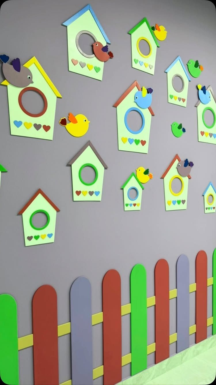 Colorful birdhouse wall decals and a multi-colored picket fence on a purple wall.