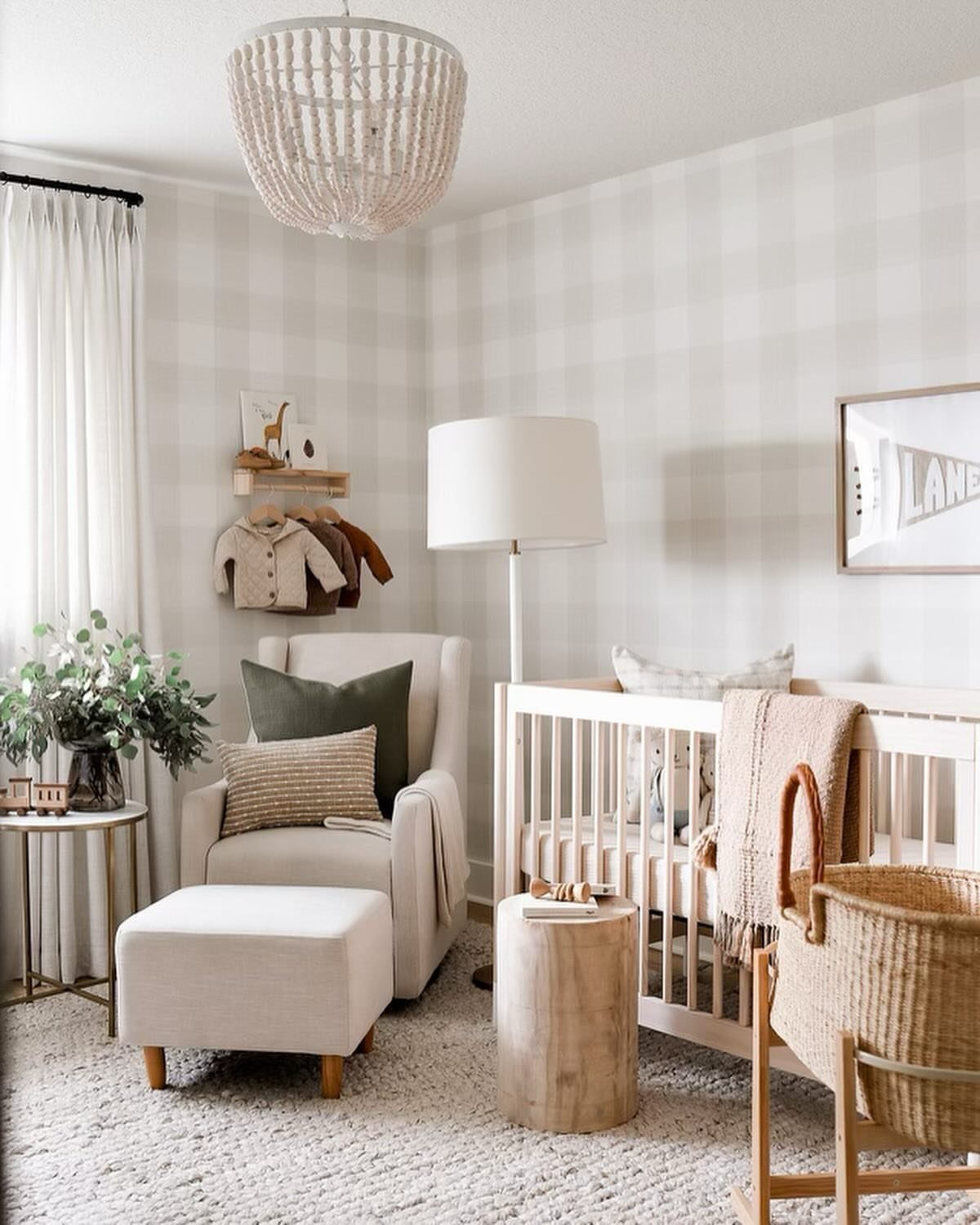 Neutral nursery with buffalo check walls, white crib, and beige glider chair.