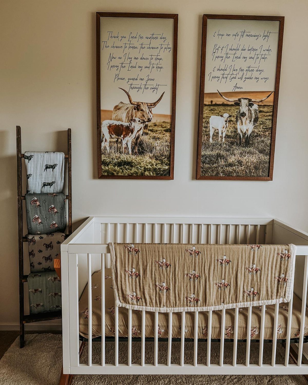 White baby crib with cow-themed bedding and framed Highland cow art on wall