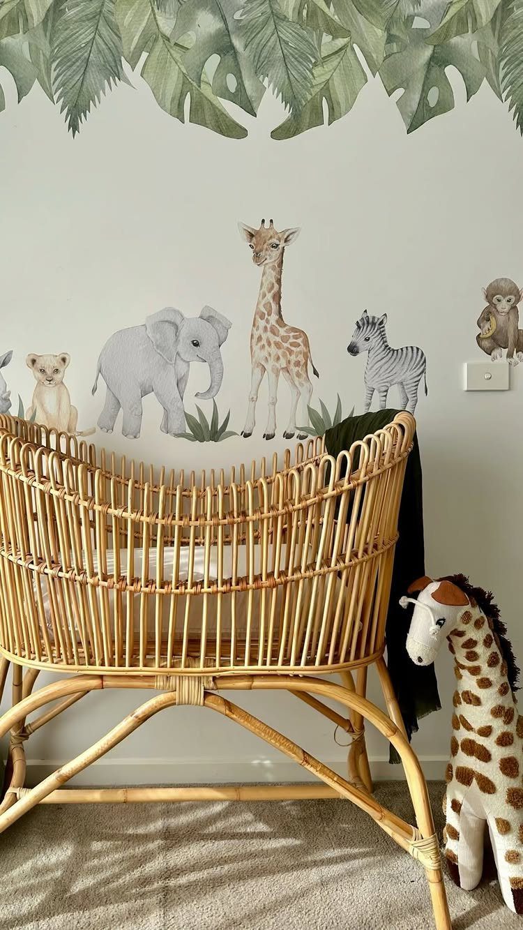 Rattan baby bassinet in front of a wall mural with safari animals