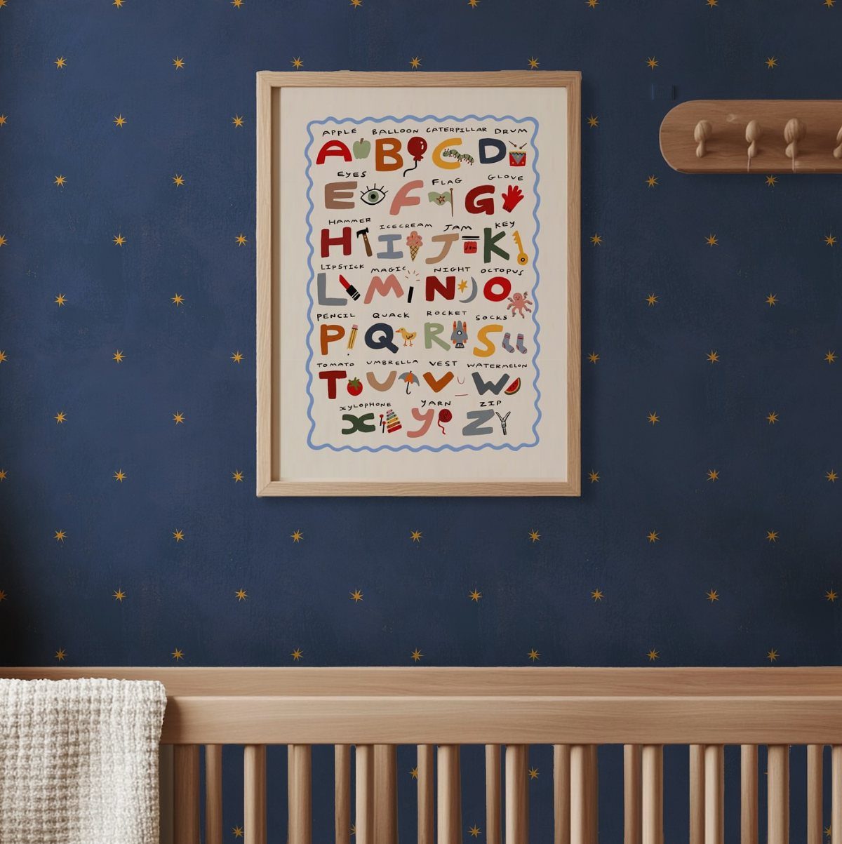 Dark blue wall with yellow stars, alphabet poster, and wooden baby crib.