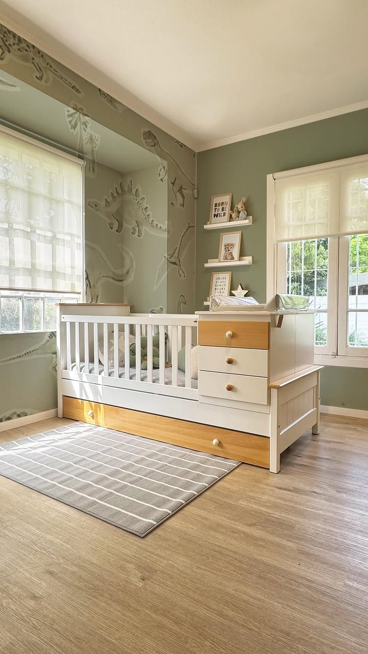 White crib with built-in storage in a small sage green nursery room