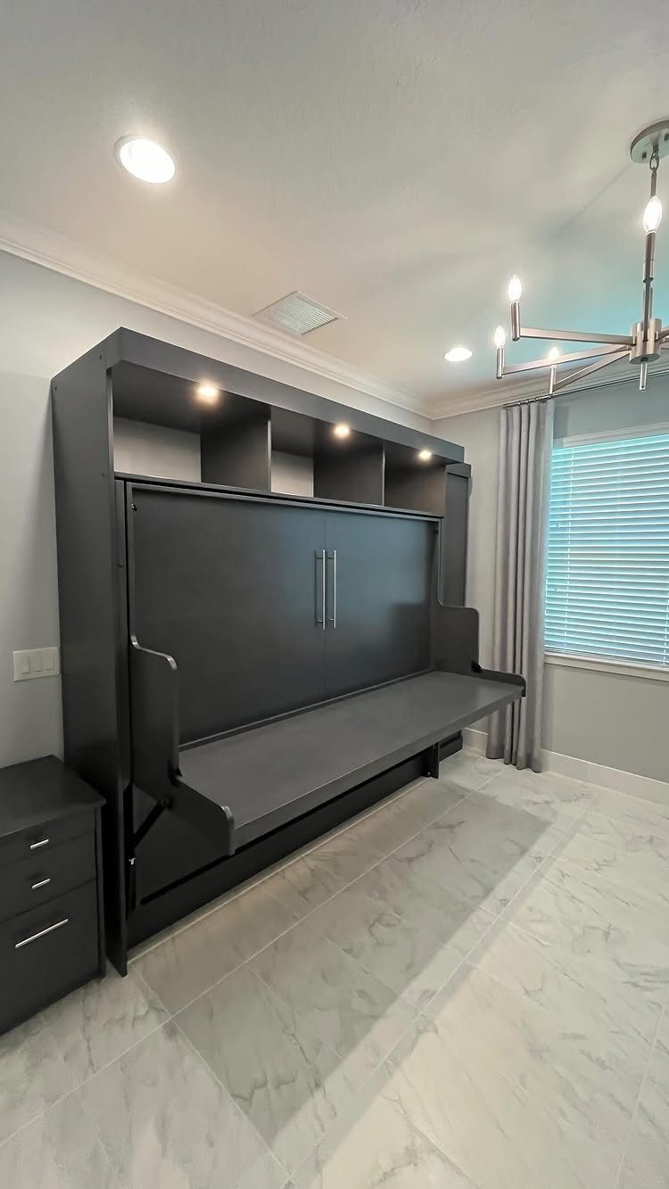 Dark grey Murphy bed with a fold-down desk in a modern bedroom office.