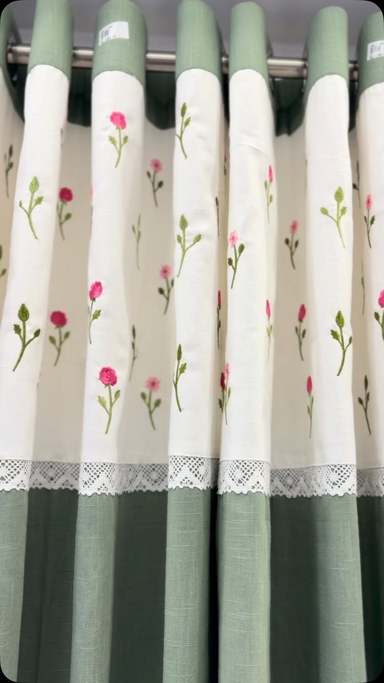 Sage green and white curtain panels with pink floral embroidery and lace trim.