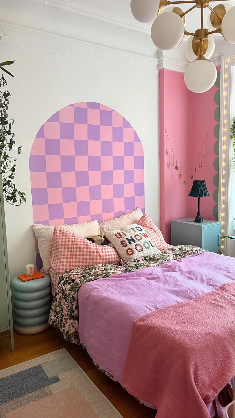 Bedroom with pink and purple checkered wall art and matching colorful bedding.