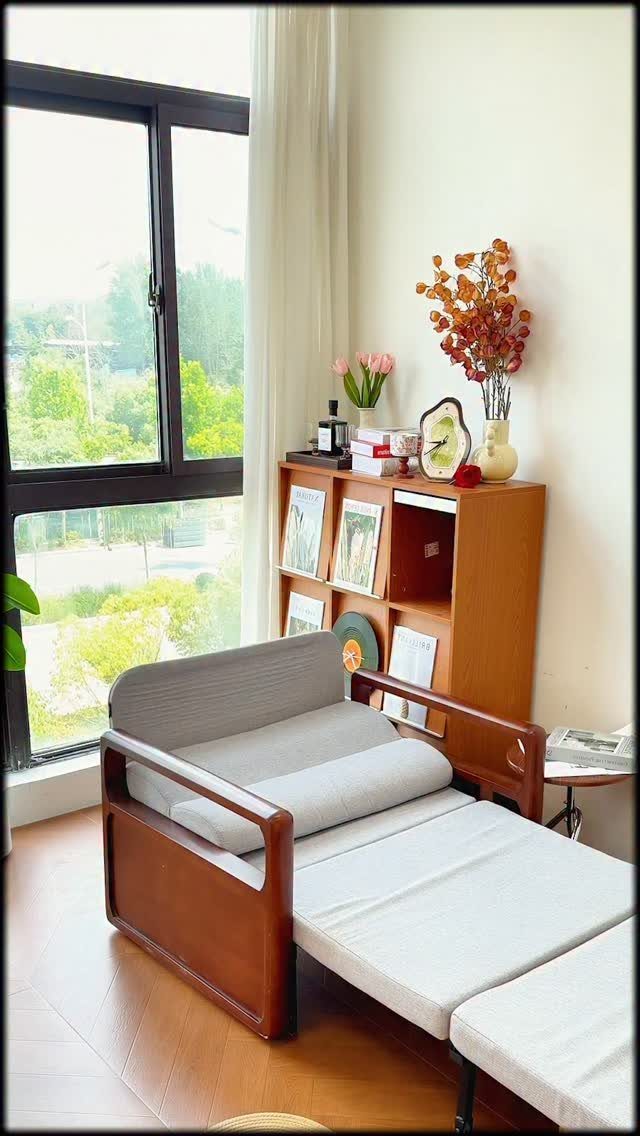 Extended sofa bed in a bright room next to a wooden bookshelf