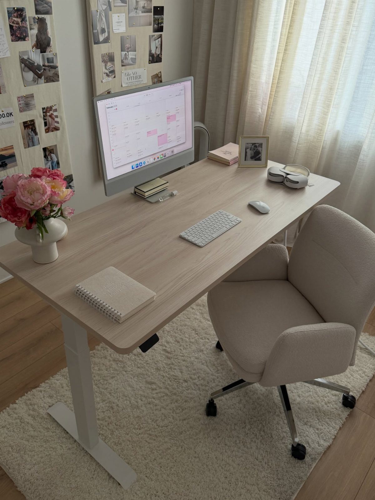 Light wood desk with computer and white chair on a white shag rug