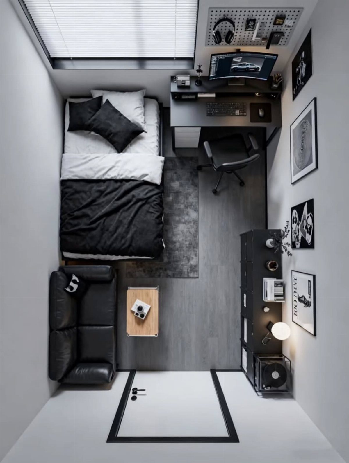 Small studio room featuring a bed, computer desk, and sofa in monochrome tones.