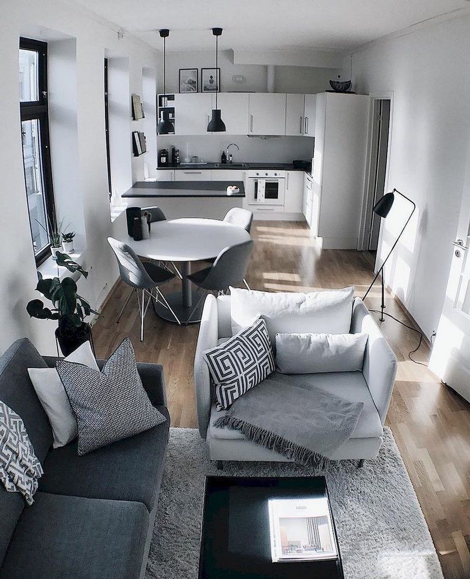 Modern open-concept apartment living room and kitchen with grey furniture and white walls