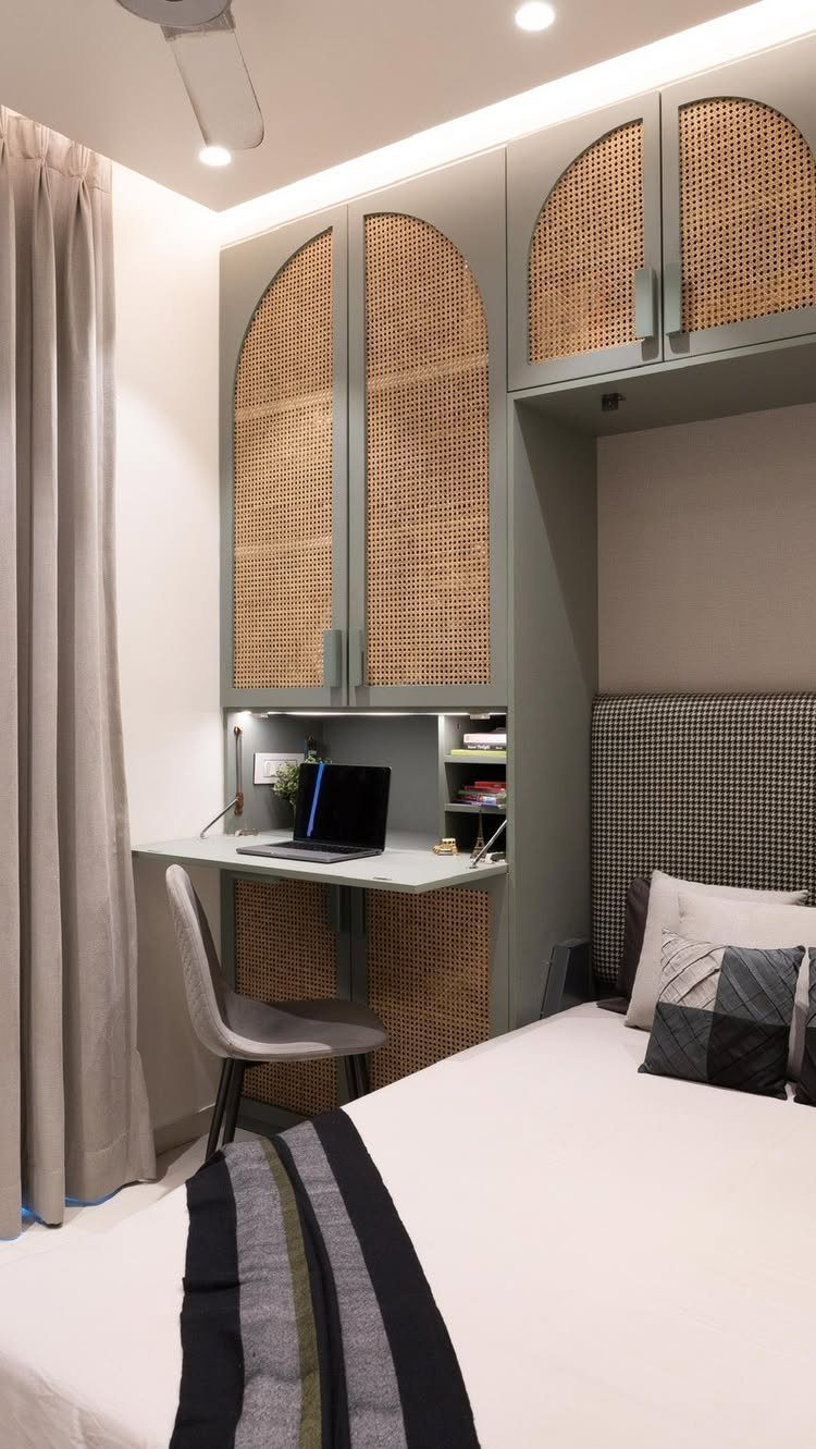 Bedroom with a built-in desk and overhead rattan cabinets next to a bed.