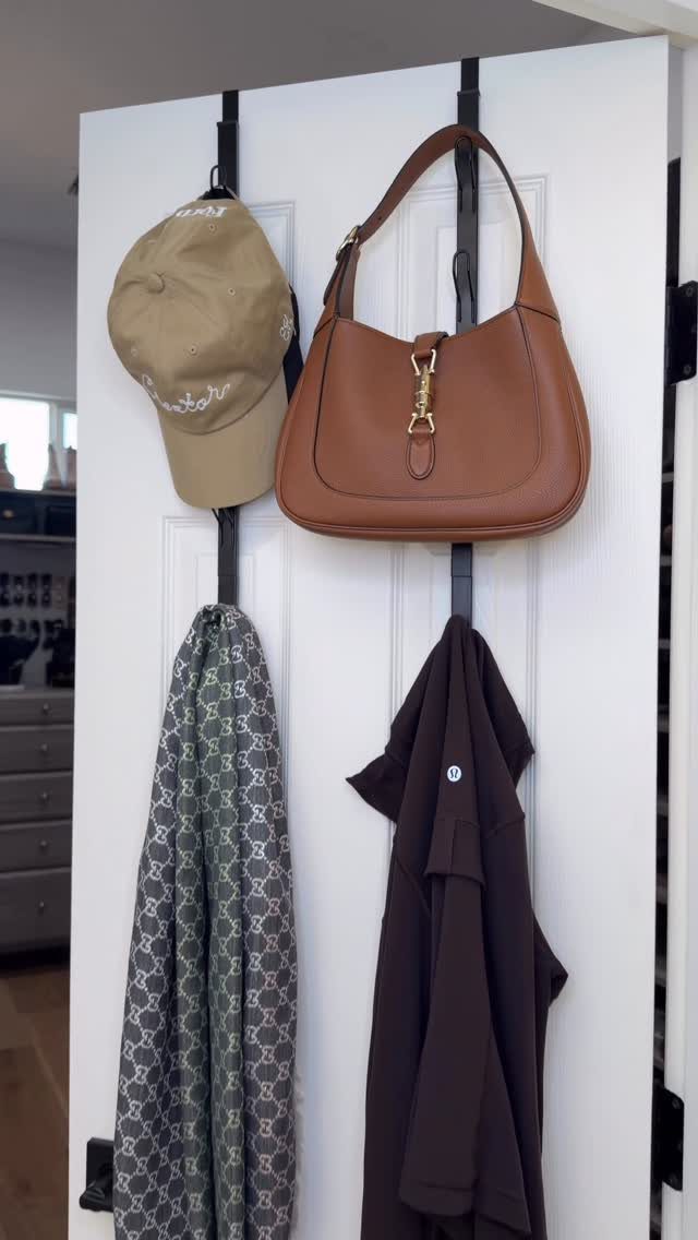 Over-the-door hanging organizers holding a tan cap, brown handbag, scarf, and dark clothing.