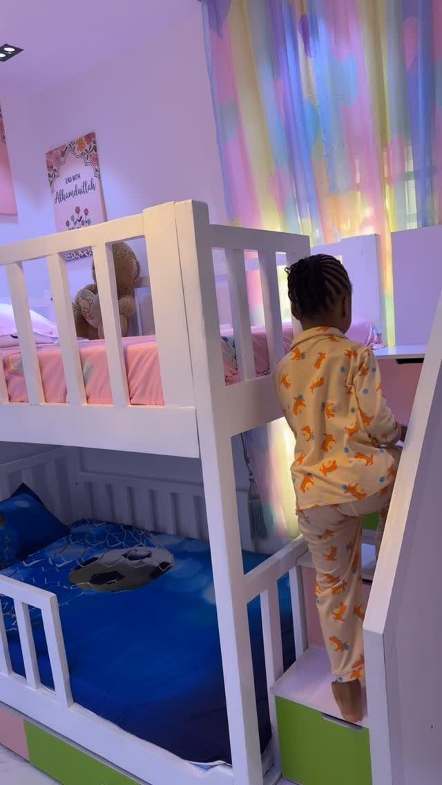 White wooden bunk bed with a child climbing the stairs in a bedroom.