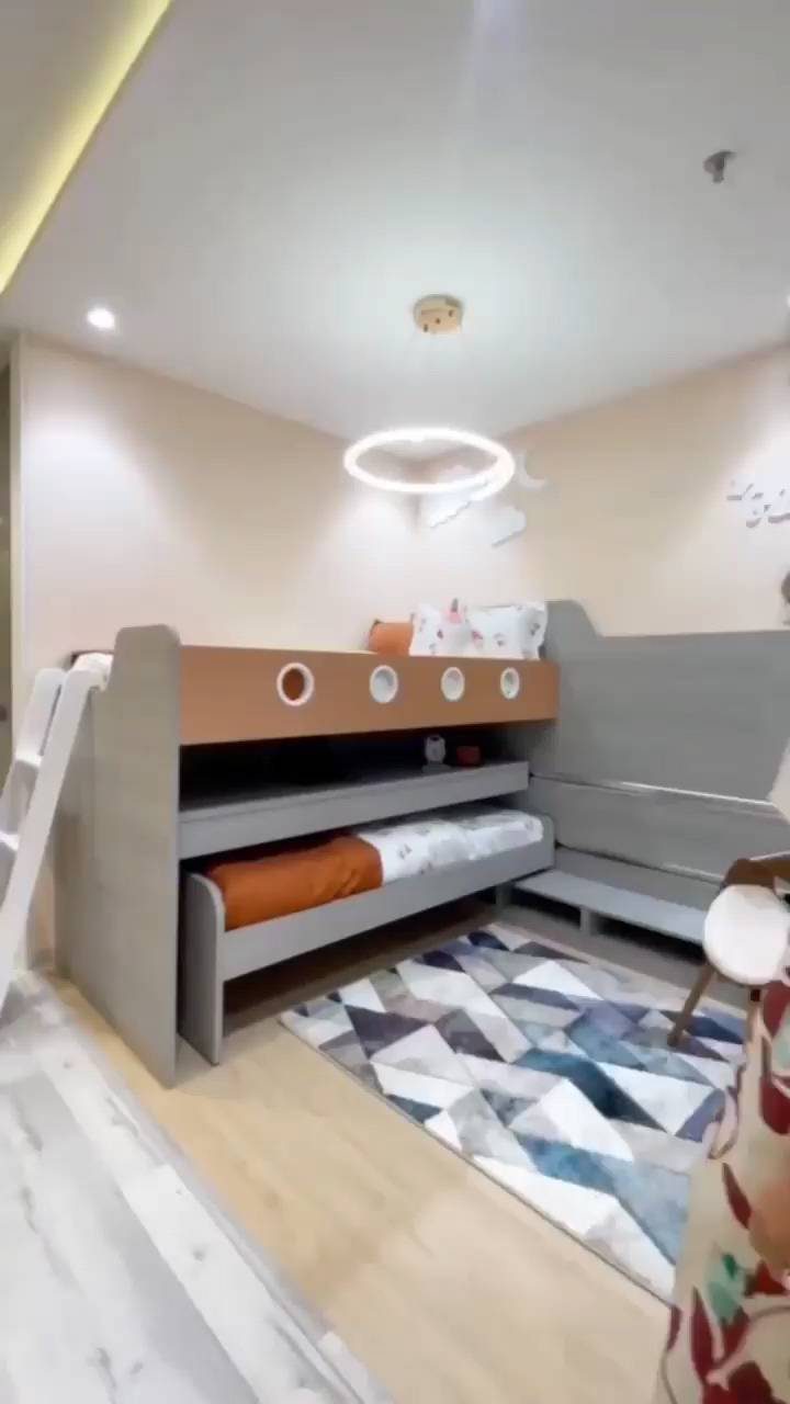 Grey bunk bed with a pull-out trundle bed in a modern bedroom