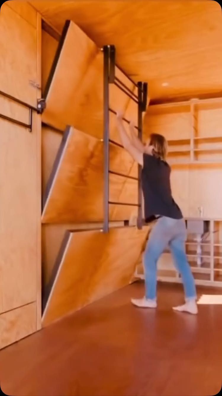 Three wooden bunk beds tilted against a wall in a wood-paneled room.