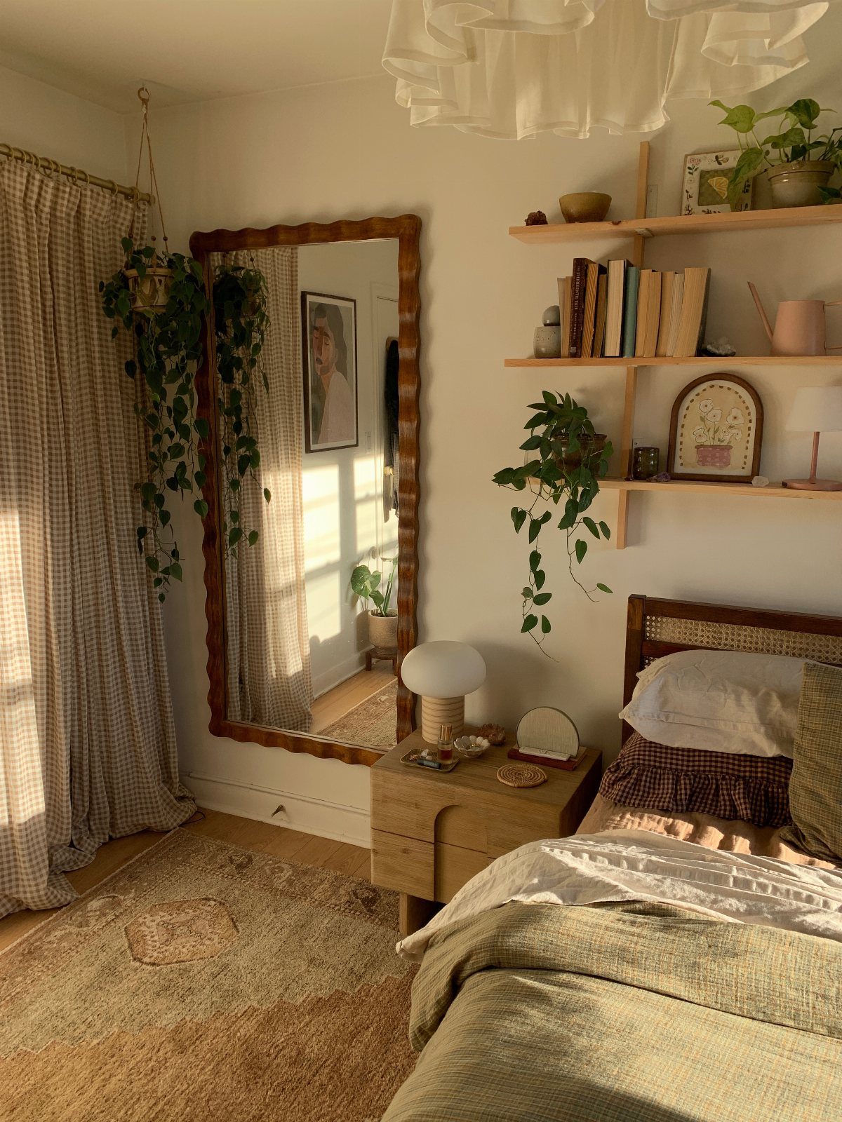 Cozy bedroom with a large wavy mirror, wooden shelves, and a textured rug.