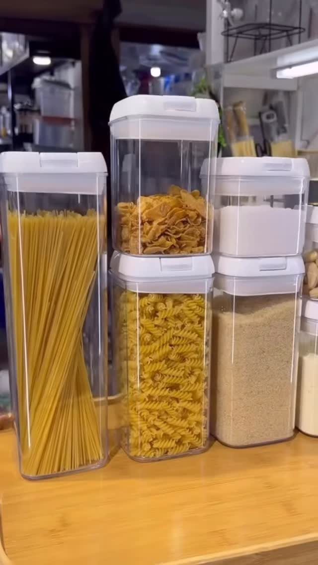 Clear stackable plastic containers filled with different types of pasta and grains.