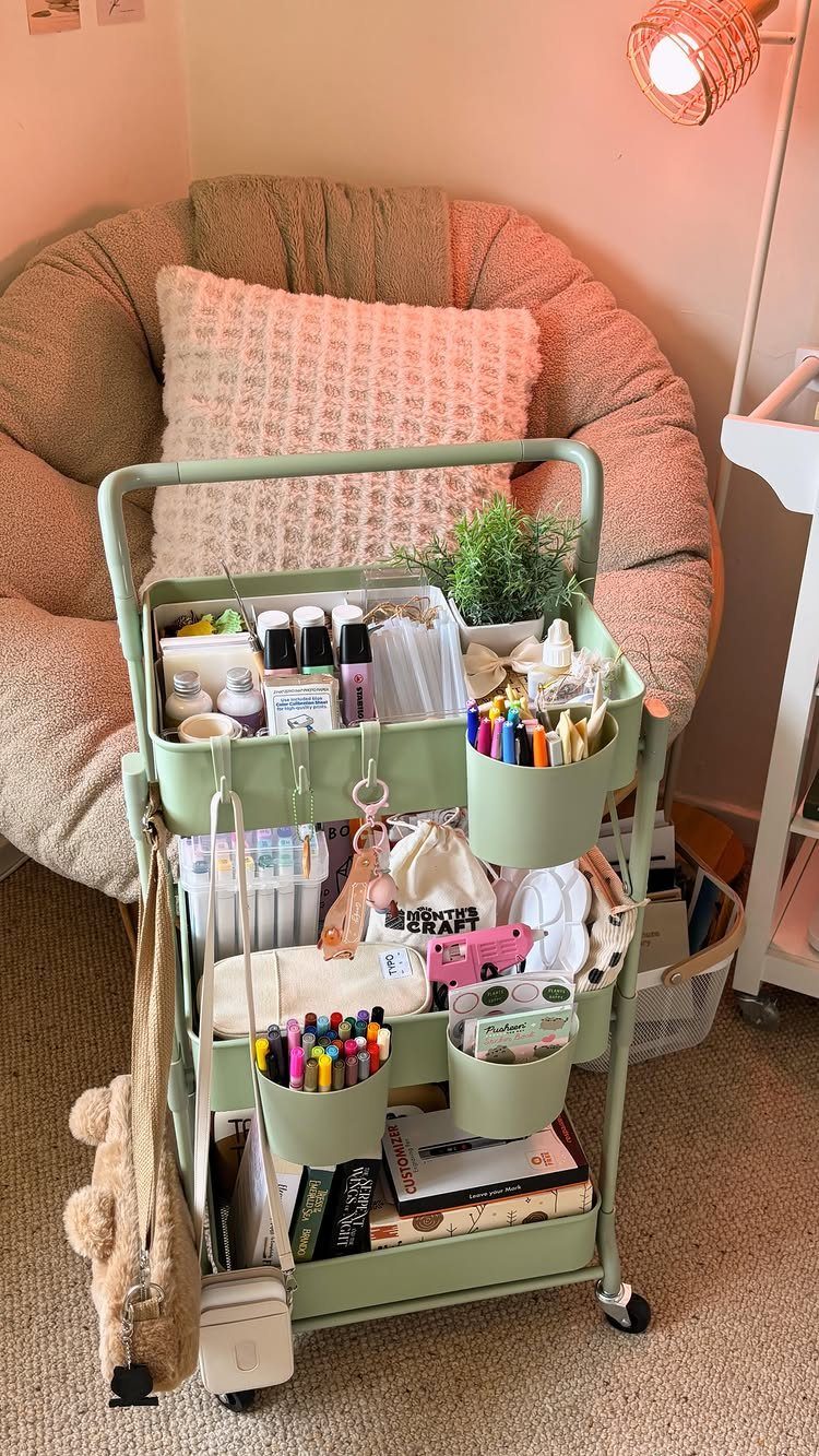 Light green rolling storage cart filled with art supplies next to a papasan chair