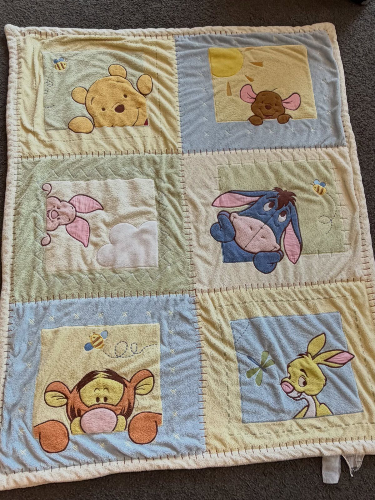 Pastel fabric quilt featuring classic Winnie the Pooh characters in six colorful panels.