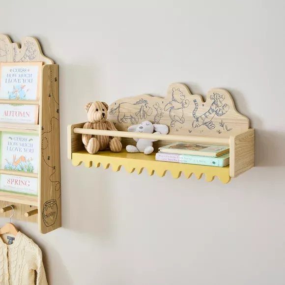 Wooden wall shelf with Winnie the Pooh illustrations, plush toys, and books.