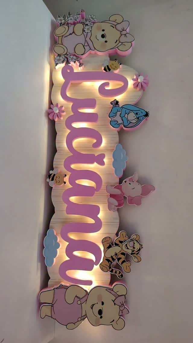 Wooden name sign for Luciana decorated with Winnie the Pooh characters and lighting.